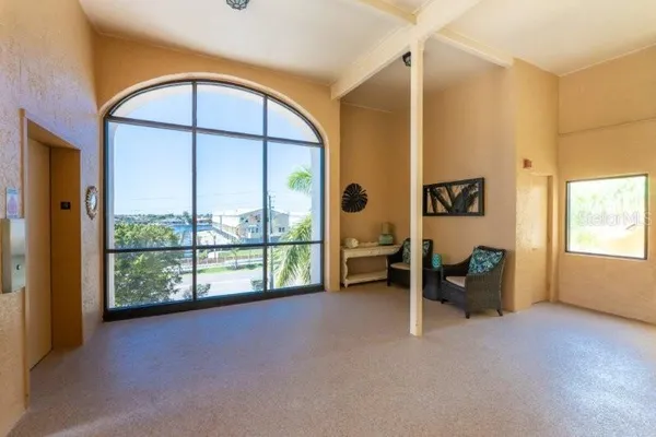 an empty room with windows and view of balcony