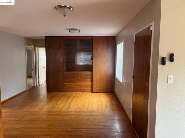 a view of an empty room with closet and a window