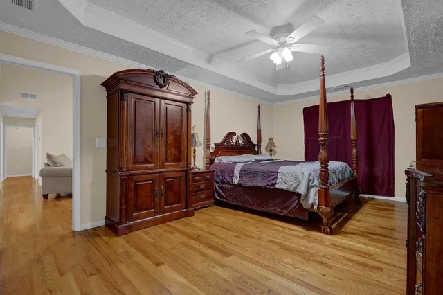 a bedroom with a bed dresser and a flat tv screen