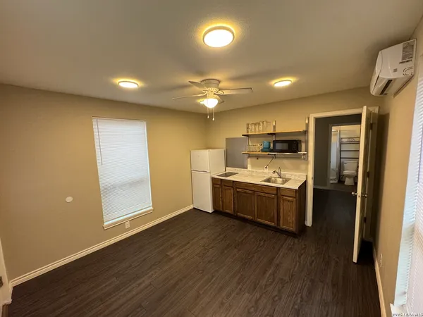 a large kitchen with a center island wooden floor and stainless steel appliances