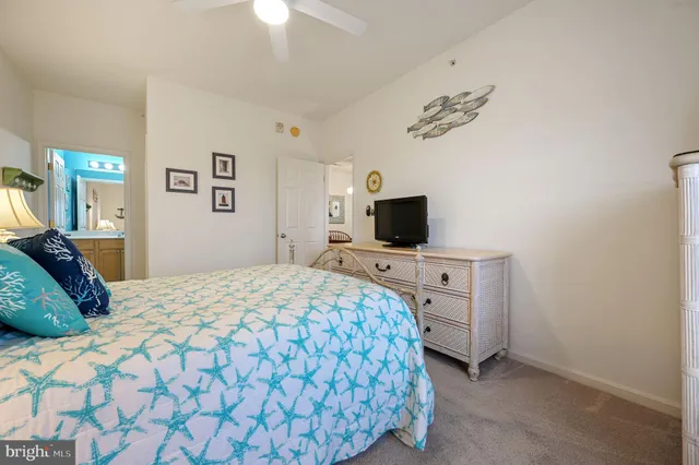 a bedroom with a bed and a flat tv screen on the dresser