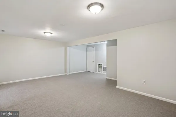 an empty room with fan and windows