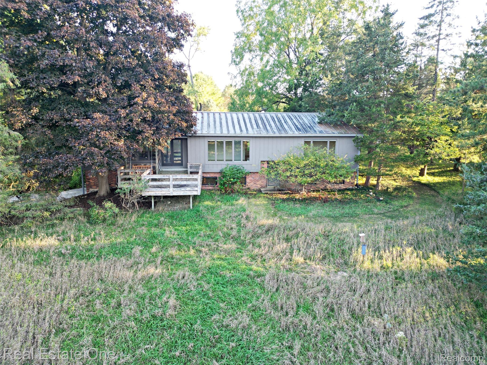 895 Rowe Road Milford, MI 48380 - Photo 1 of 50 Siding exterior with a metal roof and a wood deck
