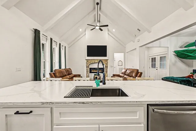 a view of a kitchen with a sink dishwasher a dining table and chairs with wooden floor