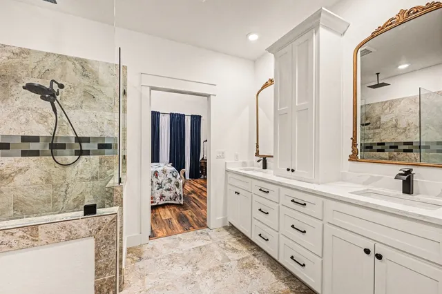 a bathroom with a double vanity sink mirror and bathtub