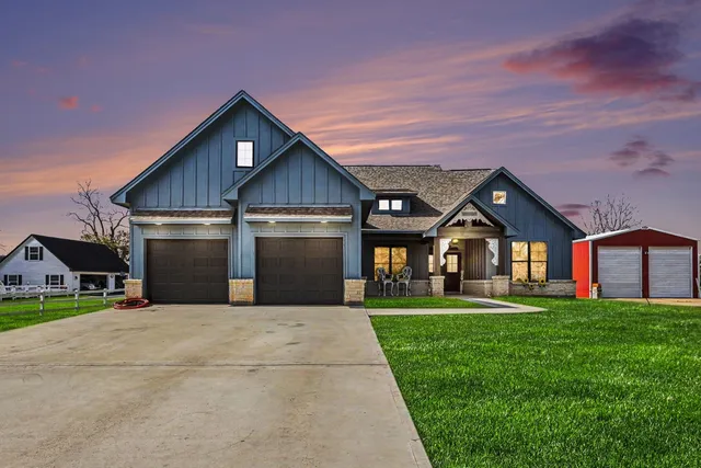 a view of a house with a big yard and large trees