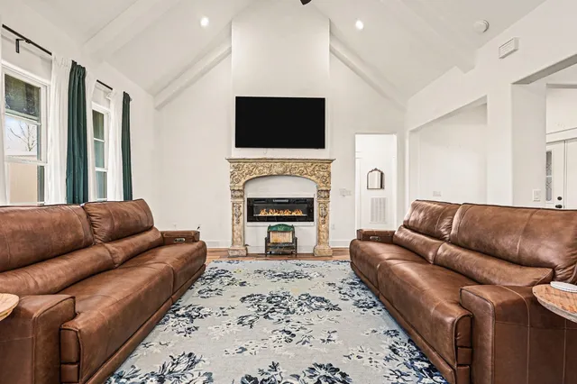 a living room with furniture a flat screen tv and a fireplace
