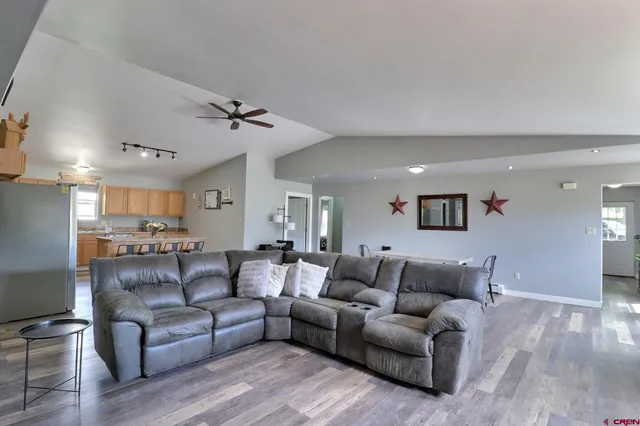 a living room with furniture and a ceiling fan