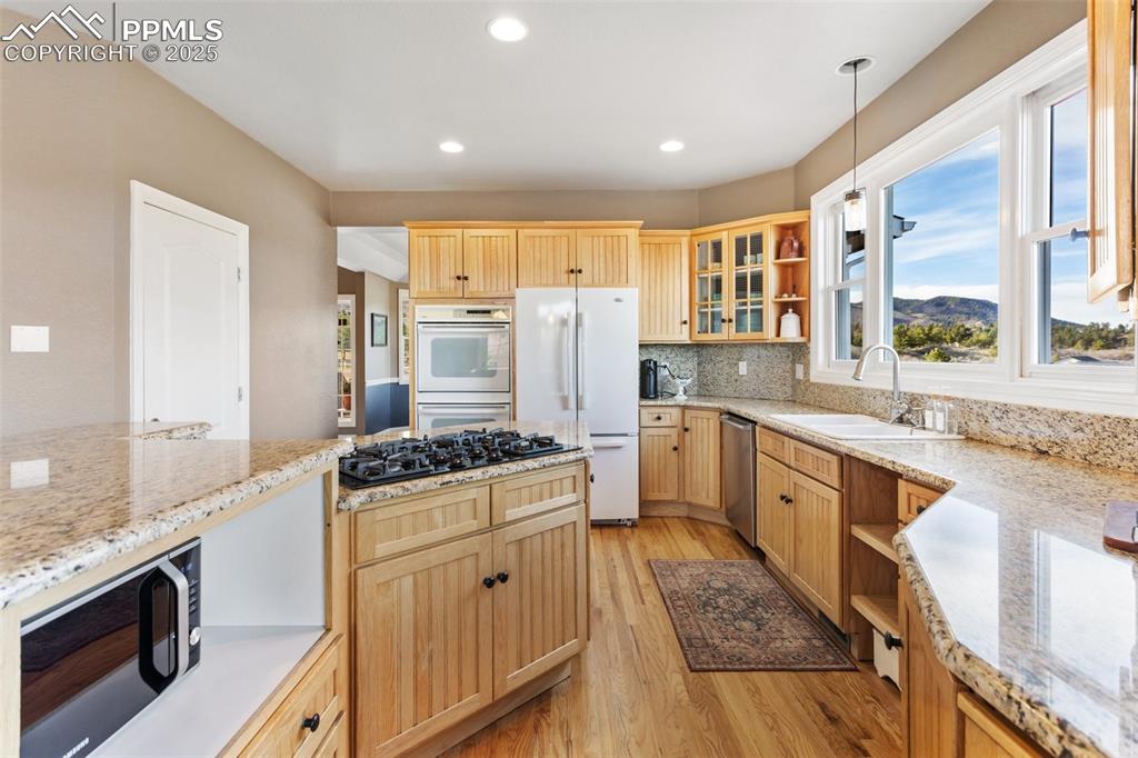 931 Forest View Road Monument, CO 80132 - Photo 14 of 50 a kitchen with a stove a sink and a refrigerator