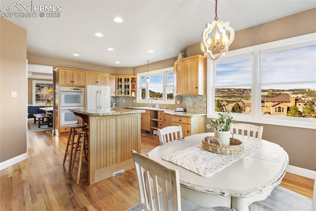 931 Forest View Road Monument, CO 80132 - Photo 15 of 50 a dining room with furniture a chandelier and wooden floor