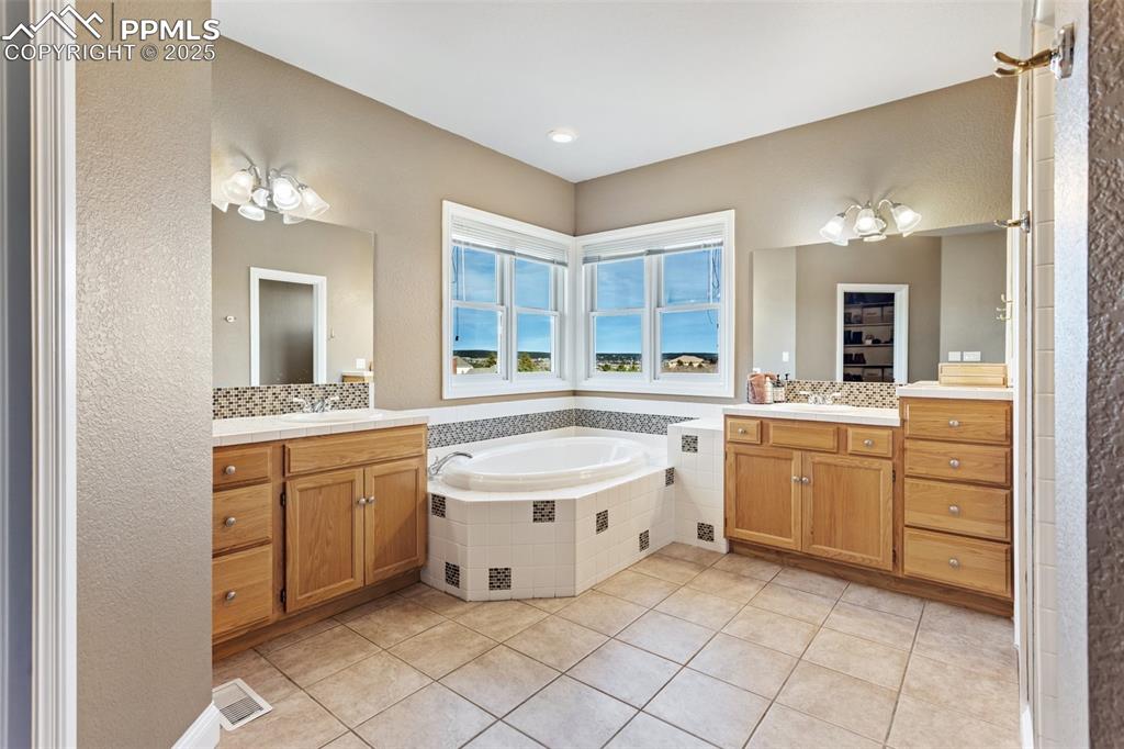 931 Forest View Road Monument, CO 80132 - Photo 25 of 50 a spacious bathroom with a granite countertop sink mirror and bathtub