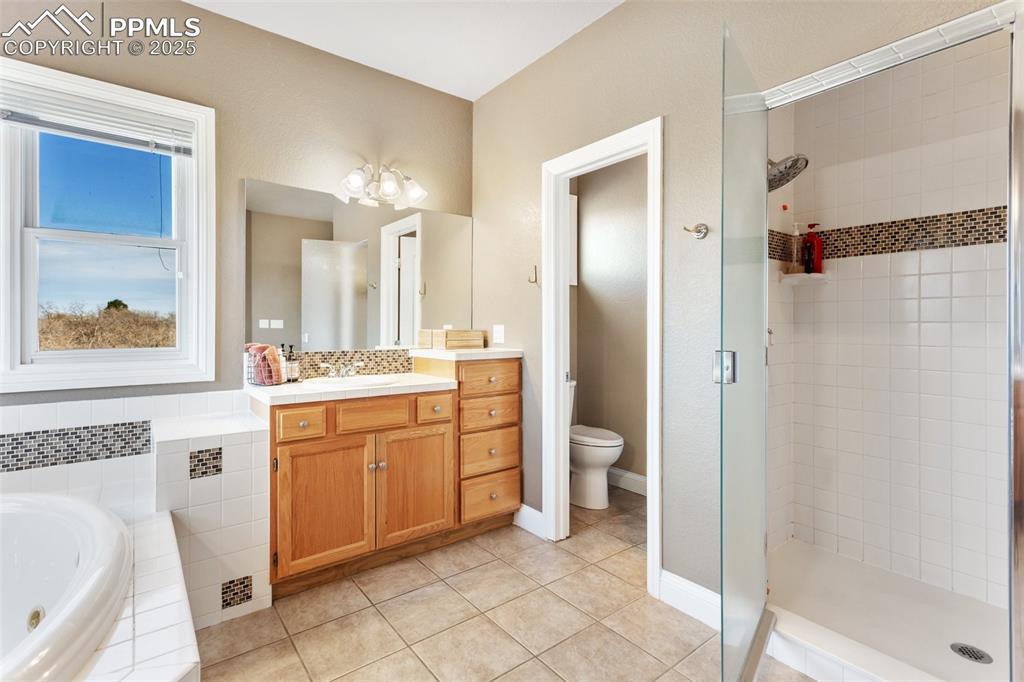 931 Forest View Road Monument, CO 80132 - Photo 26 of 50 a spacious bathroom with a granite countertop sink mirror and a bathtub
