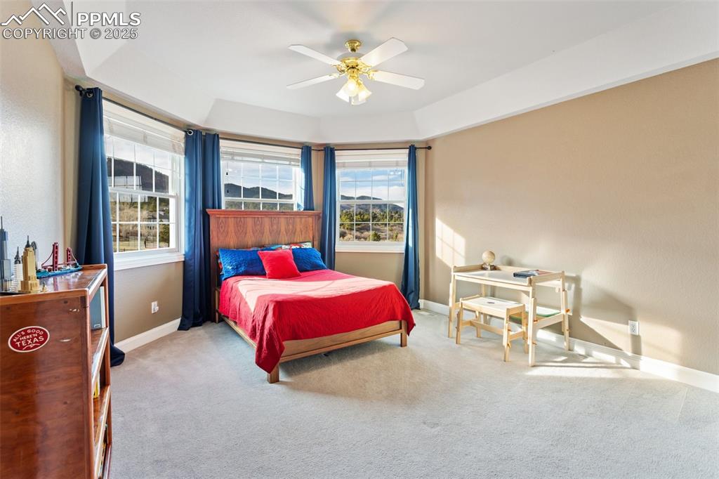 931 Forest View Road Monument, CO 80132 - Photo 27 of 50 a bedroom with a bed and a chandelier
