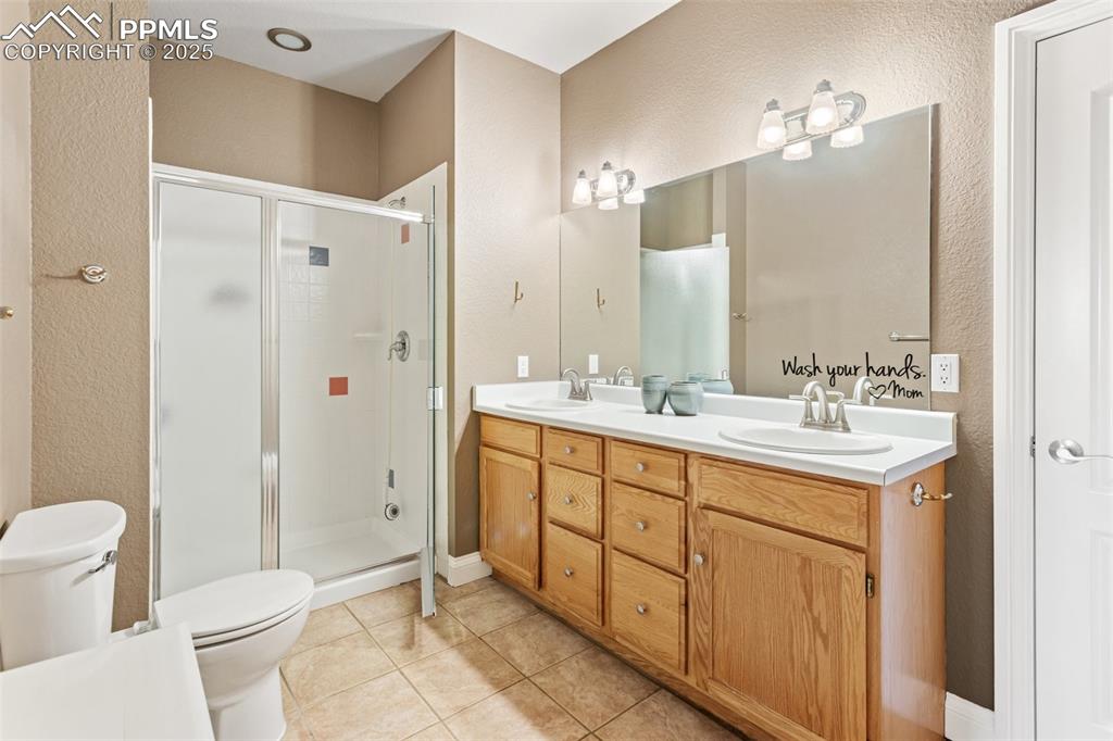 931 Forest View Road Monument, CO 80132 - Photo 32 of 50 a bathroom with a double vanity sink mirror and toilet