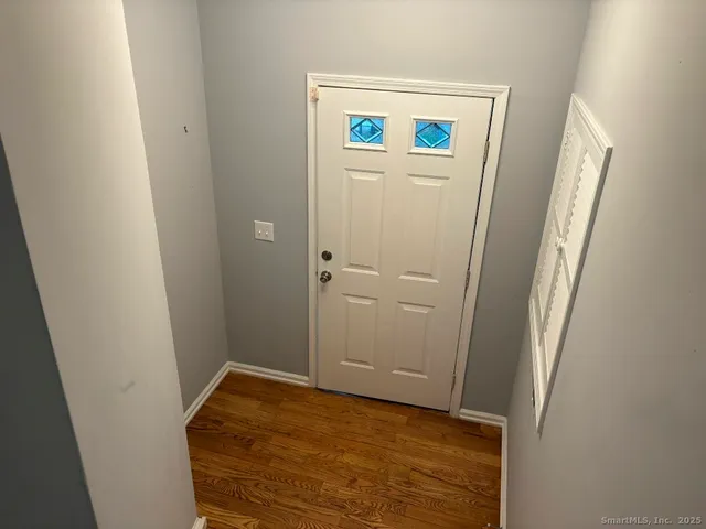 a view of a room with wooden floor and windows