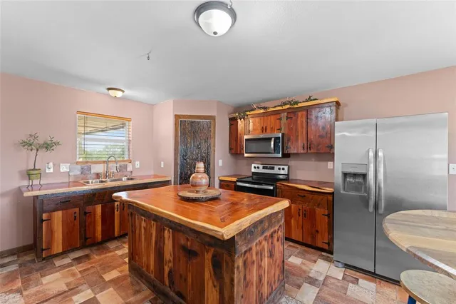 a kitchen with stainless steel appliances a sink stove refrigerator and cabinets