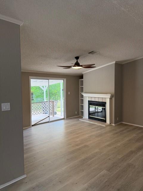 2321 Ridgeview Street Fort Worth, TX 76119 - Photo 5 of 10 Spacious interior featuring wood-finish flooring, a contemporary fireplace with white mantel and hearth, and built-in shelving