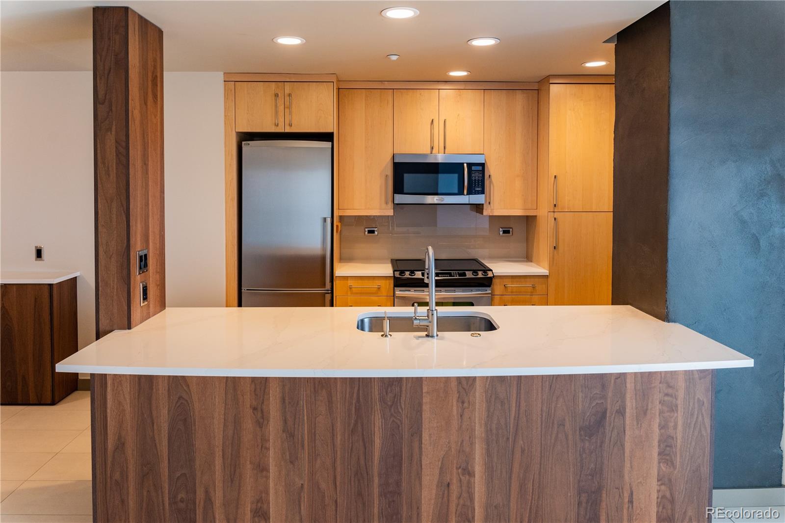 475 West 12th Avenue, Unit 15G Denver, CO 80204 - Photo 5 of 15 a kitchen with stainless steel appliances a refrigerator sink and microwave