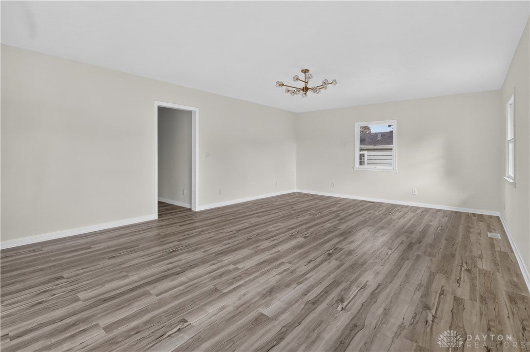 1243 Student Avenue Springfield, OH 45503 - Photo 10 of 38 Rich wood floors sweep across a versatile living space illuminated by multiple windows.