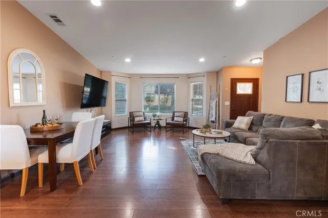 a living room with furniture flat screen tv and wooden floor