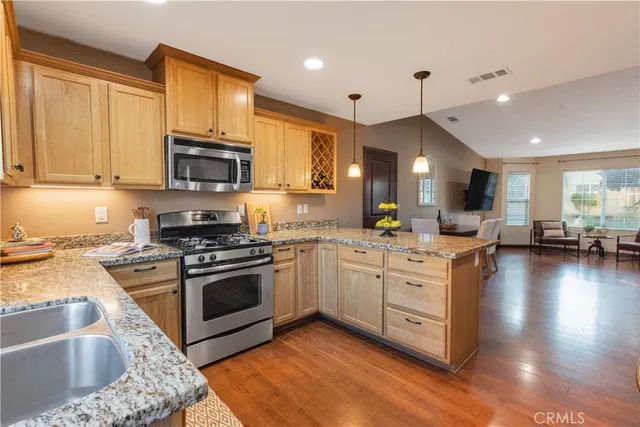 a kitchen with stainless steel appliances granite countertop a sink stove and refrigerator