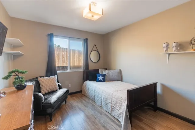 a bedroom with a bed wooden floor and window