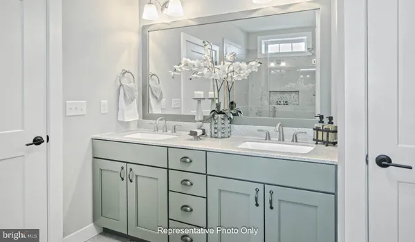 a bathroom with double vanity sinks and a mirror