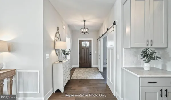 a view of a hallway with windows and chandelier