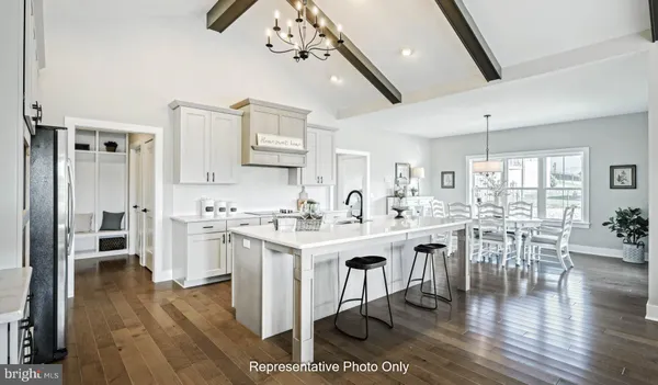 a kitchen with white cabinets and chairs