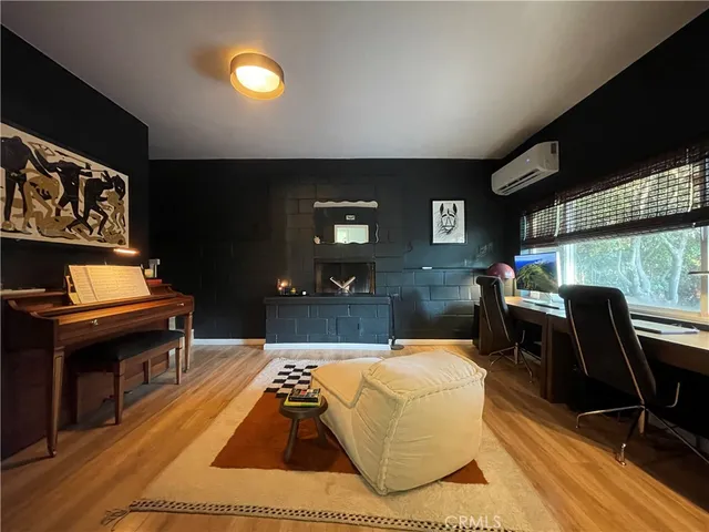 a living room with furniture a piano and a flat screen tv