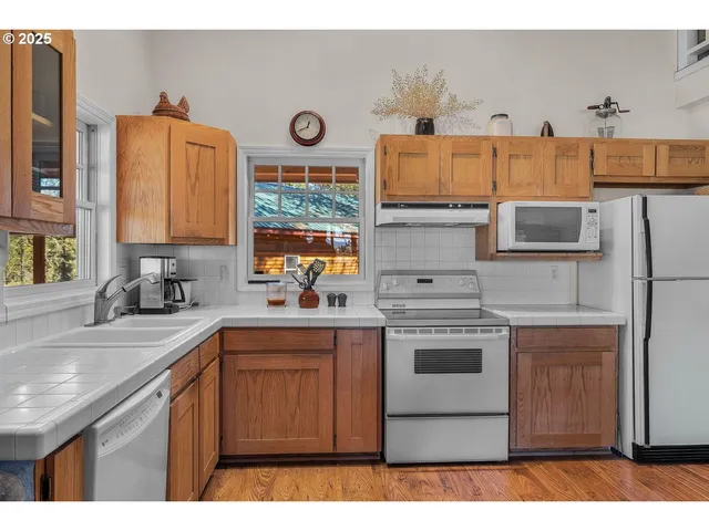 a kitchen with stainless steel appliances a stove a sink and a microwave