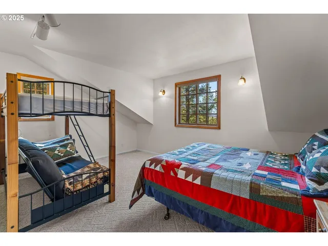 a bedroom with a bed next to a window with storage