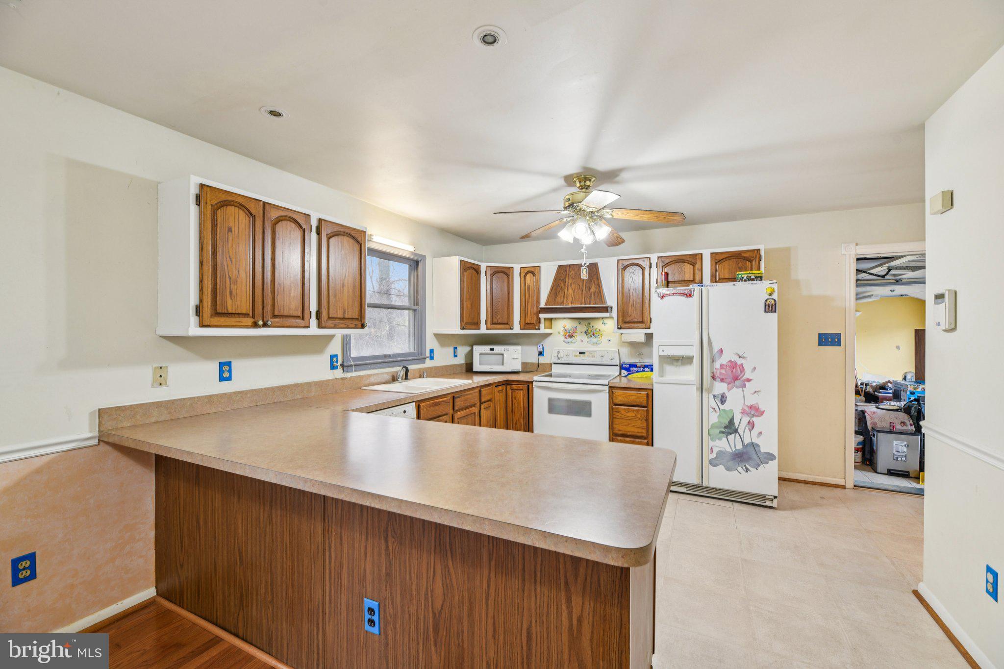 2650 Solomons Island Road Huntingtown, MD 20639 - Photo 13 of 44 a kitchen with stainless steel appliances granite countertop a sink dishwasher and a refrigerator with wooden floor