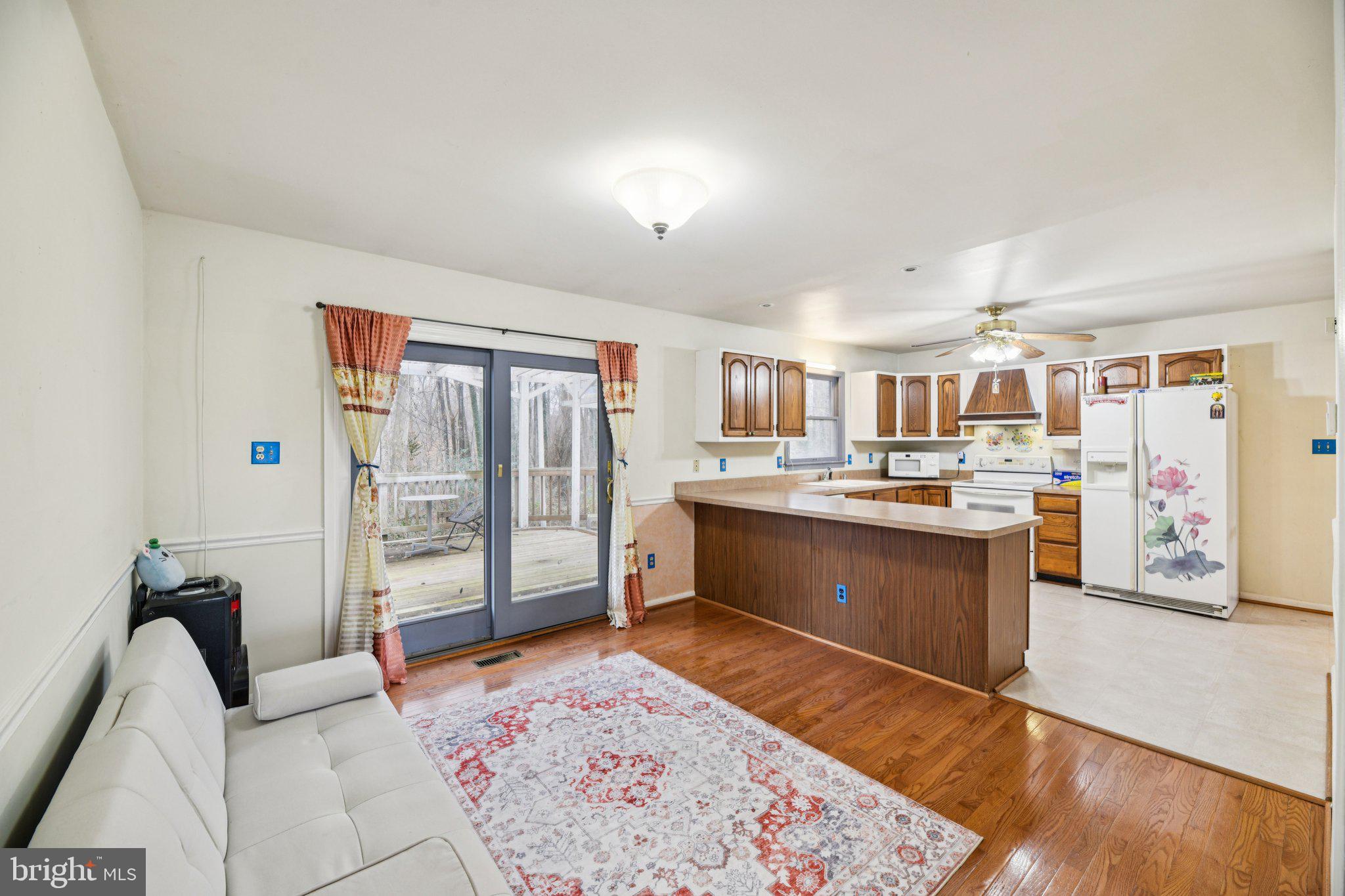 2650 Solomons Island Road Huntingtown, MD 20639 - Photo 7 of 44 a large living room with stainless steel appliances kitchen island granite countertop a couch and a bookshelf in it