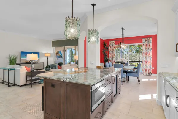 a view of a dining room and livingroom with furniture wooden floor a chandelier
