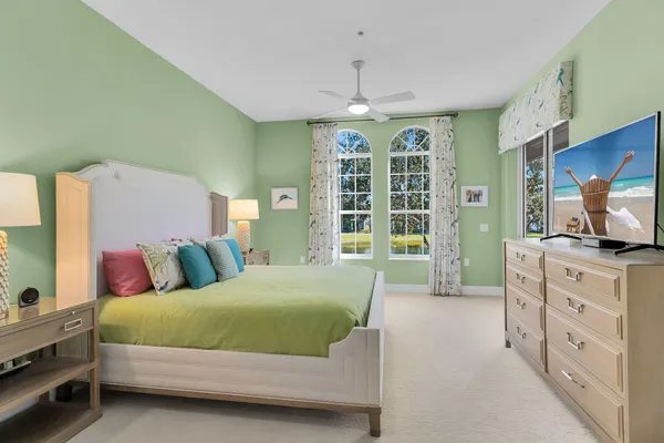 a bedroom with a large bed and a flat tv screen on dresser