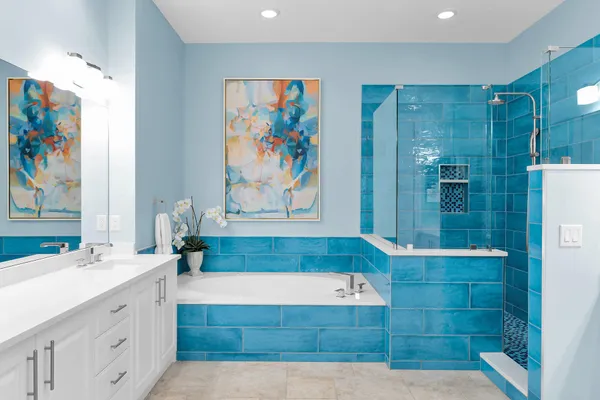 a bathroom with a tub a sink and glass door
