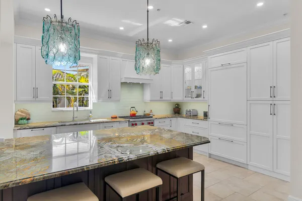 a kitchen with kitchen island granite countertop a stove a sink a refrigerator and a granite counter tops