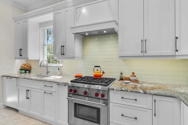 a kitchen with stainless steel appliances granite countertop a sink stove and cabinets