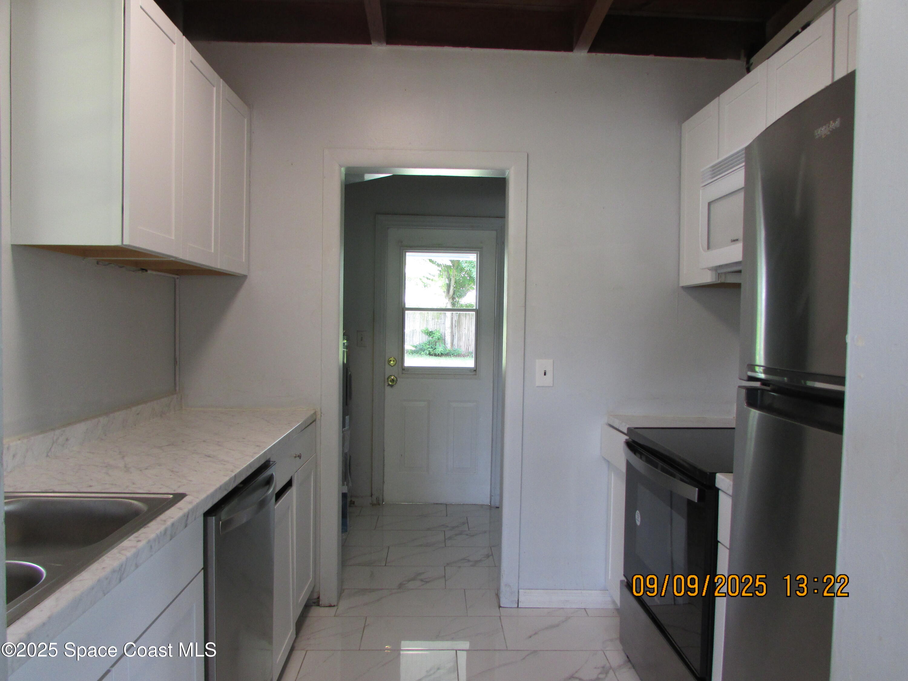 1647 Dixie Way Melbourne, FL 32935 - Photo 4 of 15 a kitchen with a refrigerator and cabinets