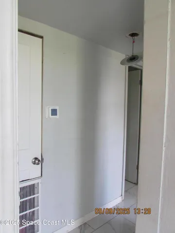 a view of a hallway with wooden floor and closet
