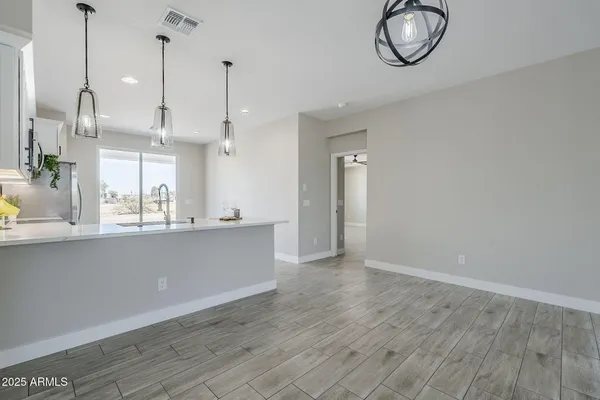 a kitchen with stainless steel appliances a sink stove and wooden floor