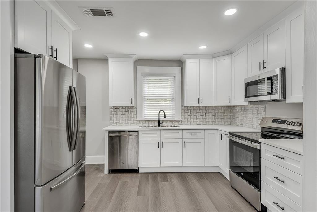 2300 Dauphine Street Atlanta, GA 30344 - Photo 11 of 34 a kitchen with white cabinets stainless steel appliances and a refrigerator