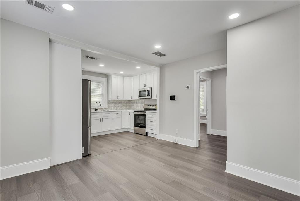 2300 Dauphine Street Atlanta, GA 30344 - Photo 13 of 34 a view of a kitchen with a sink and dishwasher a refrigerator with wooden floor