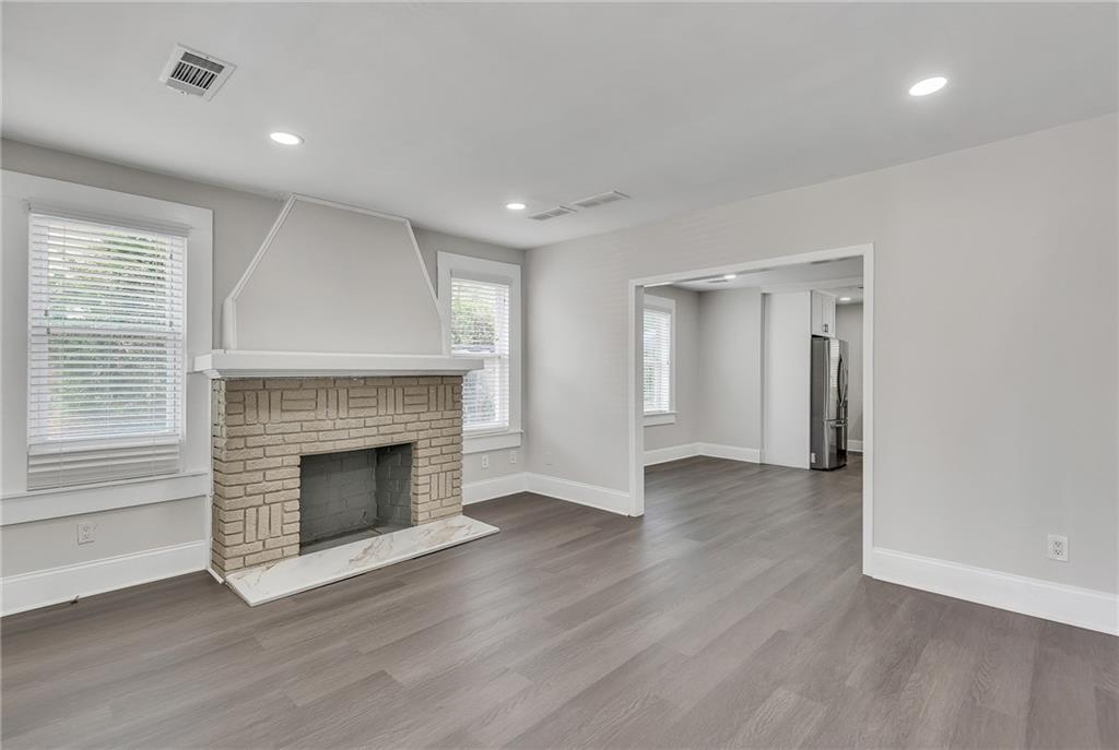 2300 Dauphine Street Atlanta, GA 30344 - Photo 10 of 34 an empty room with wooden floor fireplace and windows