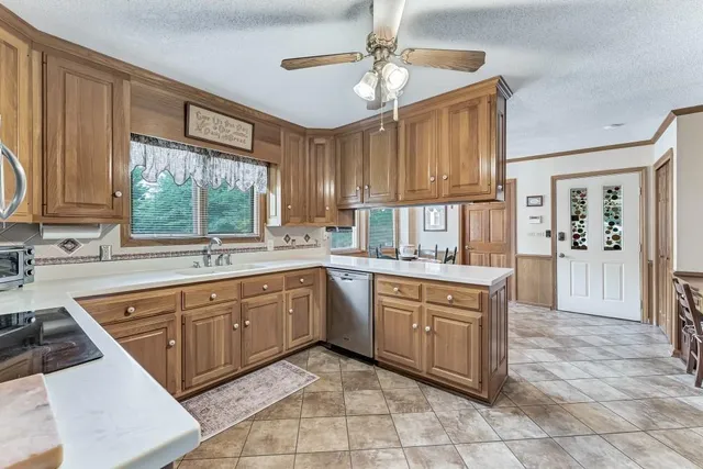 a large kitchen with kitchen island granite countertop a sink window and cabinets