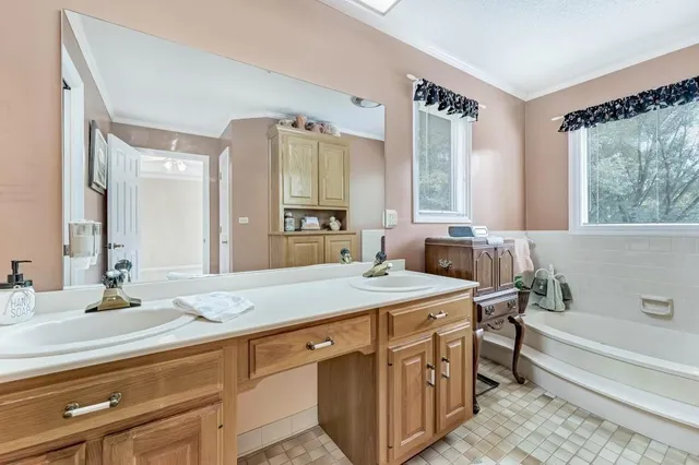 a bathroom with a granite countertop sink mirror and a bath tub