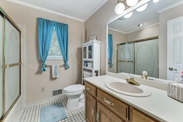 a bathroom with a sink toilet double vanity and shower
