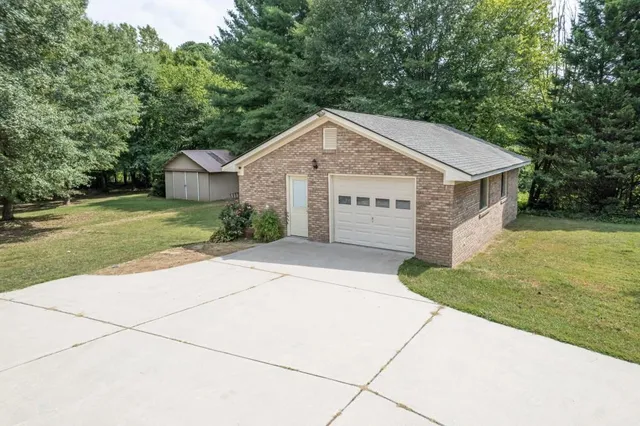 a view of a house with a yard and large tree