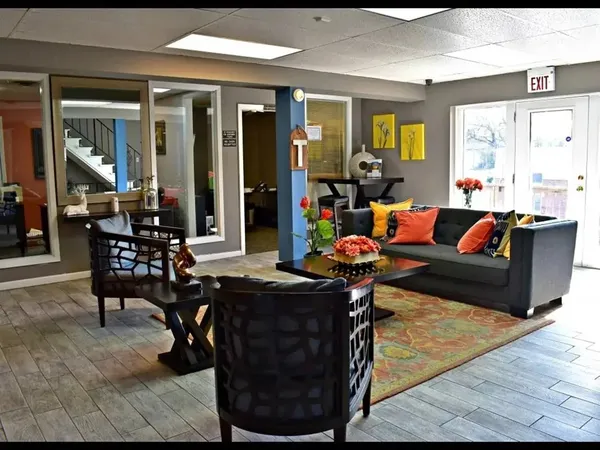 a living room filled with furniture and large windows